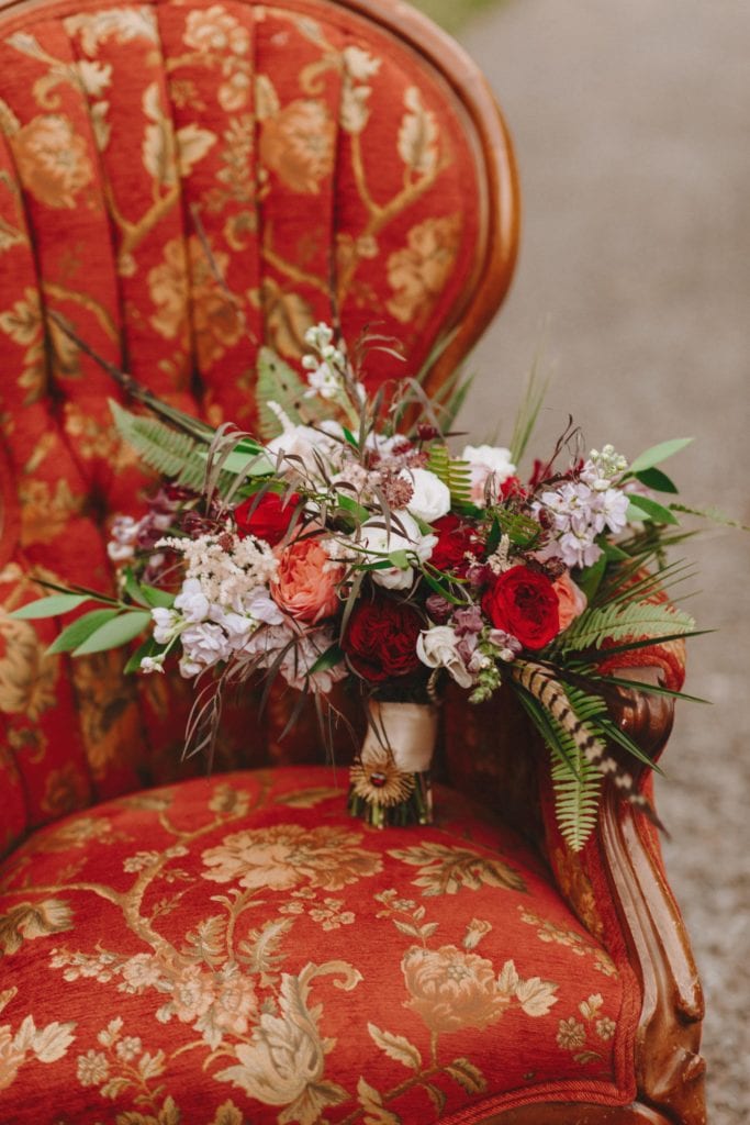 Blush and burgundy bridal bouquet with garden roses and pheasant feathers
