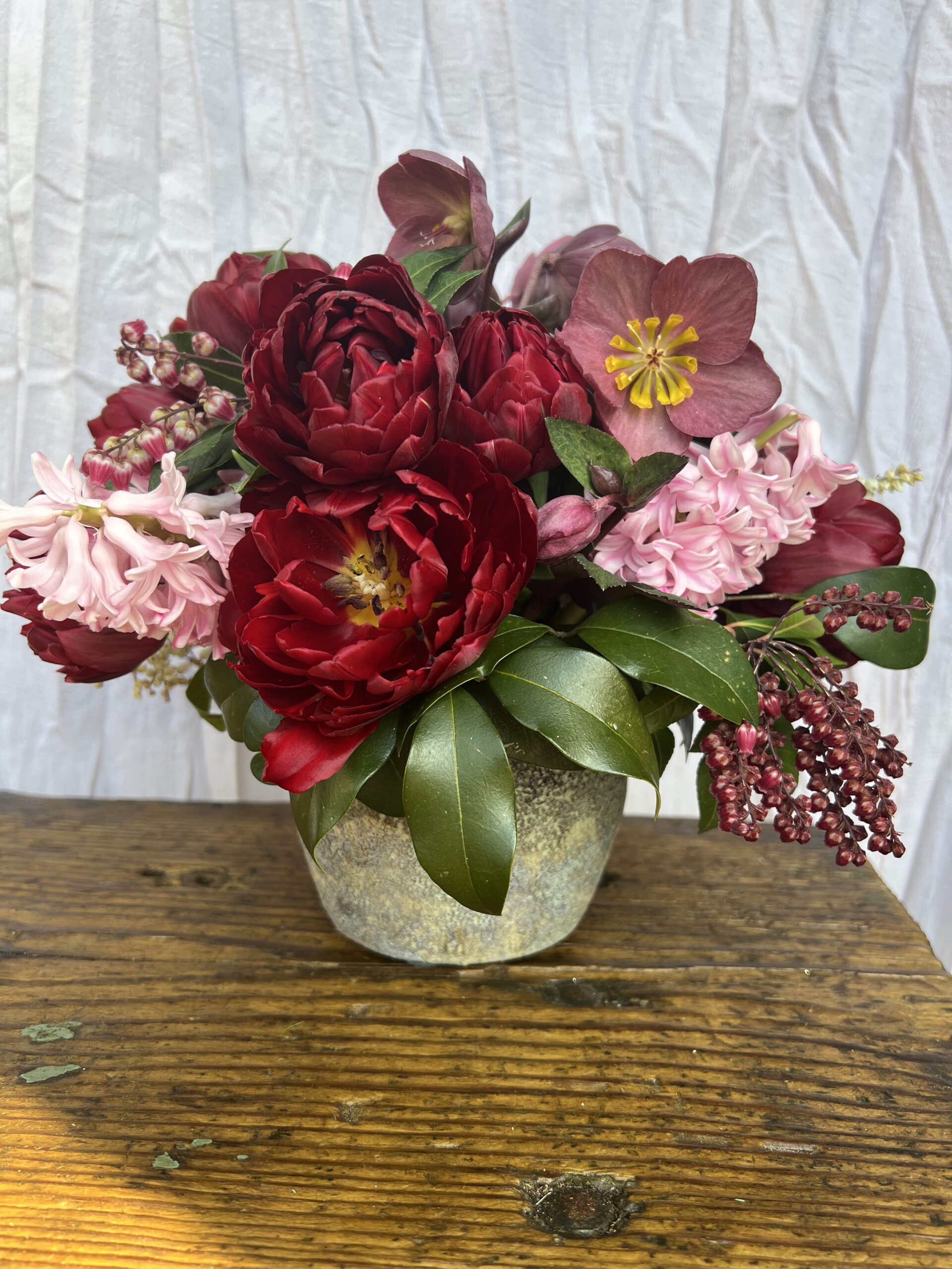 burgundy and pink floral arrangement with tulips, hellebore and hyacinth